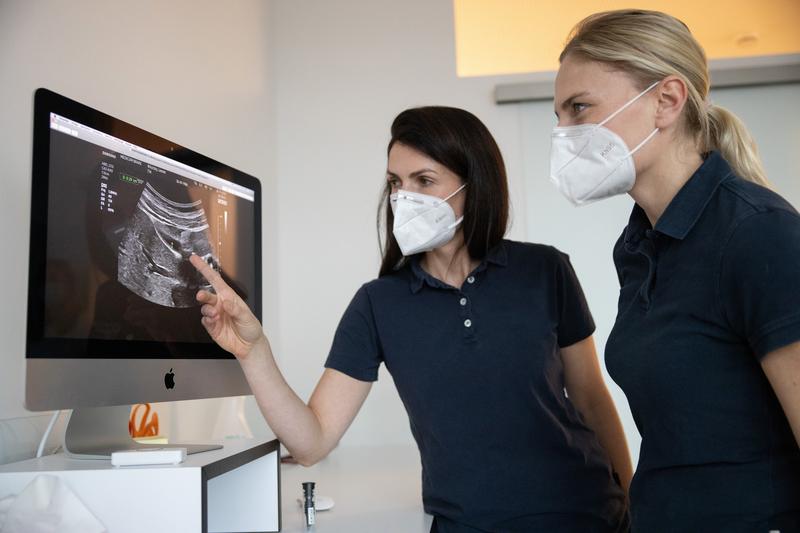 Zwei rztinnen begutachten ein Ultraschallbild auf einem Monitor.